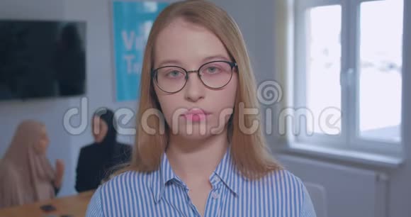 肖像年轻美丽悲伤眼镜白种人金发办公室背景视频的预览图