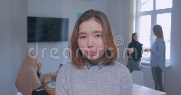 背景中一个年轻美丽悲伤的亚洲女办公室肖像视频的预览图
