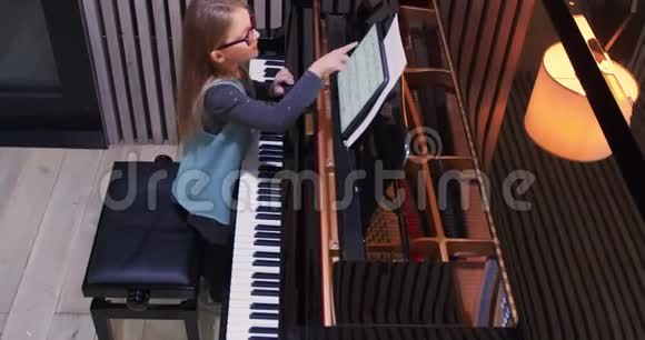 孩子在家学弹钢琴孩子练钢琴侧视小女孩弹钢琴视频的预览图