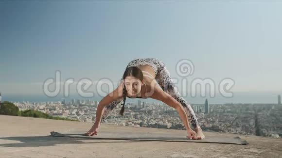 从巴塞罗那的角度伸展身体的女人在城市做瑜伽的运动女孩视频的预览图