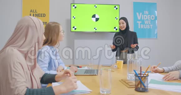 四位充满自信性格开朗的同事办公室女头巾讨论商业计划展示色彩艳丽的笑声视频的预览图