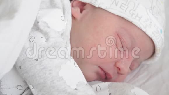 在生命的最初几天里一个新生婴儿的脸被特写他在梦中颤抖微笑和伸展A视频的预览图