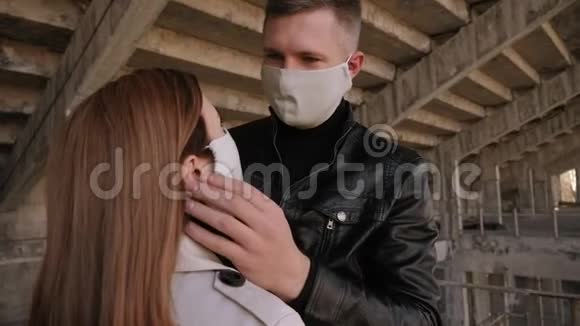 一个恋爱中的男人戴着一个保护性的医疗面具拥抱他的女朋友视频的预览图