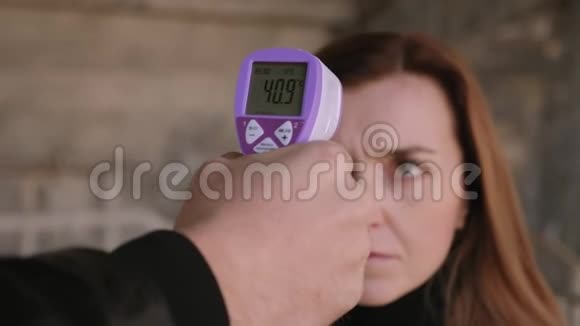 男人用无接触温度计测量温度给一个年轻的女人视频的预览图