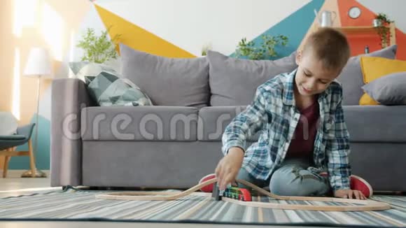 快乐的孩子喜欢玩玩具车在家里独自玩地板视频的预览图