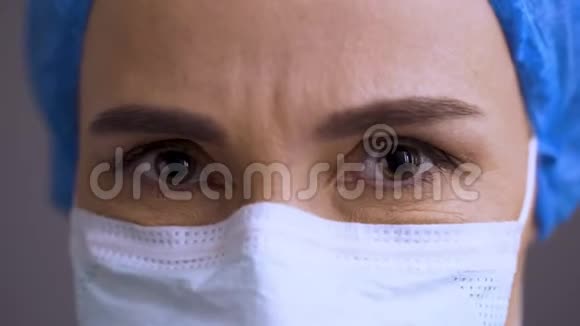 女医生脸上贴着医用口罩神情严肃带着遗憾点头外科女头否认视频的预览图