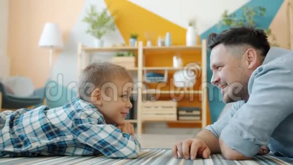 幸福的家庭中年父亲和可爱的小儿子在家笑着说笑视频的预览图