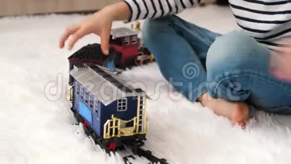 一个快乐的孩子正在房间里玩耍坐在地板上这个男孩正在建造一条铁路玩着视频的预览图