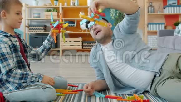 快乐的家庭父亲和小男孩玩玩具然后在家里玩得很开心视频的预览图