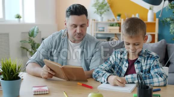 父亲和儿子在家里画画和读书玩得开心视频的预览图