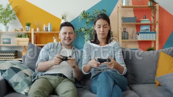男人和女人在玩电子游戏而快乐的孩子在家拥抱父母视频的预览图
