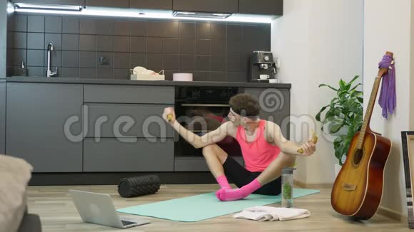 性感合身的男人有胡子和粉红色的运动服用香蕉代替哑铃在肱二头肌上做锻炼有趣的家伙视频的预览图