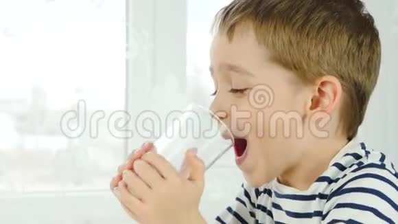 一个小男孩从杯子里喝牛奶体验快乐快乐笑声的情绪健康自然婴儿食品视频的预览图