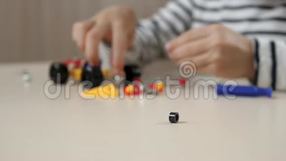 幼儿设计一个小玩具汽车的模型一个快乐的孩子坐在桌子旁玩一个构造函数相机视频的预览图