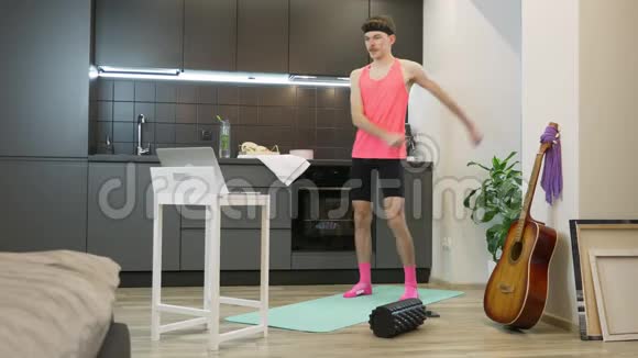 滑稽愚蠢的健身男子跳舞享受音乐和热身在厨房在家里锻炼有趣的男运动员视频的预览图