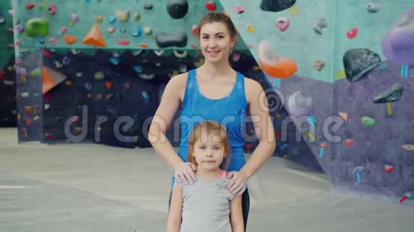 母亲和女儿站在攀岩设施里看镜头的肖像视频的预览图
