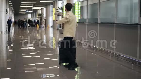长胡子的年轻人带着手提箱等着他的女朋友在机场乘飞机回家出差很久后视频的预览图