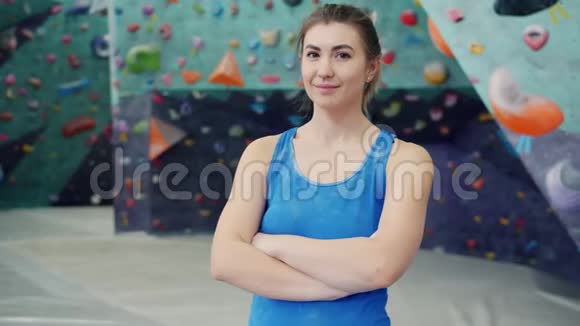 迷人的年轻女子独自站在攀岩中心微笑的画像视频的预览图