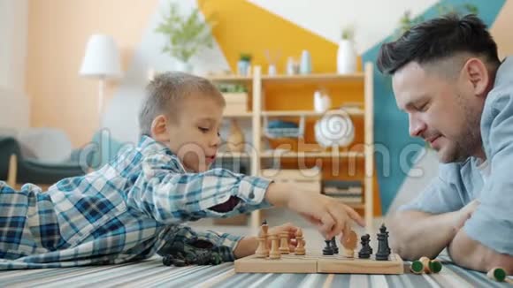小孩和有爱心的父亲一起在家玩象棋视频的预览图