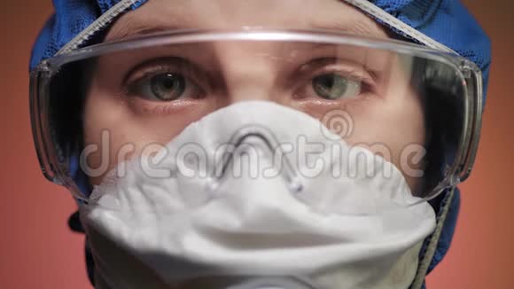 戴防毒面具的肖像女孩戴着防护服戴着眼镜看着摄像机警报流行病流行病COVID视频的预览图