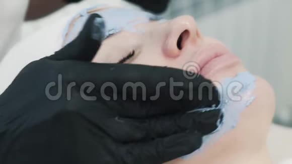 美容师使用蓝色粘土创新面膜的侧视图视频的预览图