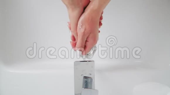 女性洗手在盆地冠状病毒期间的卫生一个女人用肥皂在白色的水槽上洗手以消除细菌视频的预览图