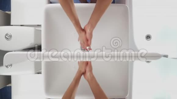 女性洗手在盆地冠状病毒期间的卫生一个女人用肥皂在白色的水槽上洗手以消除细菌视频的预览图