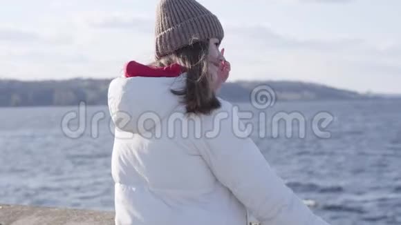 站在河岸上的体贴的年轻女子的侧视图美丽的白人黑发女孩在休息视频的预览图