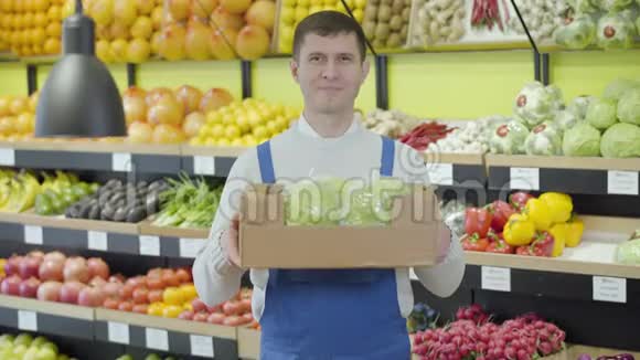 成年白种人男子拿着装有新鲜有机卷心菜的盒子对着镜头微笑的肖像专业推销员视频的预览图