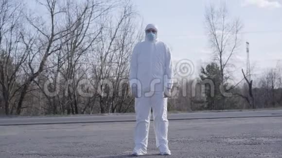 穿着防护服站在路上的白人男子阳春天年轻病毒学家画像视频的预览图