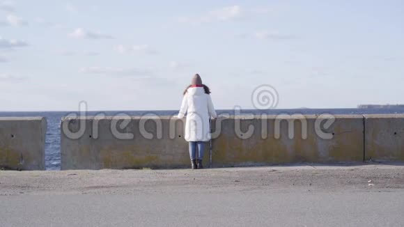一个孤独的白种人女孩站在空荡荡的城市上远远地看着深色女人的后景视频的预览图