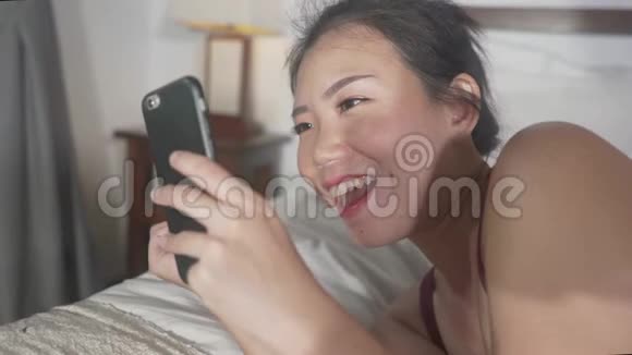 美丽快乐的亚洲韩国女性使用手机社交媒体与男友发短信或享受在线约会视频的预览图