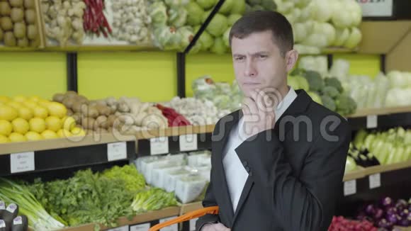 黑种人白人男子的肖像棕色的眼睛站在杂货店和思考穿着优雅西装的正经男人视频的预览图