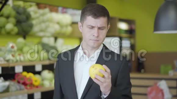 自信认真的男人在超市挑选梨的肖像年轻的白人选择黄色水果出售视频的预览图