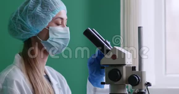 女性实验室工作人员研究显微镜样本视频的预览图