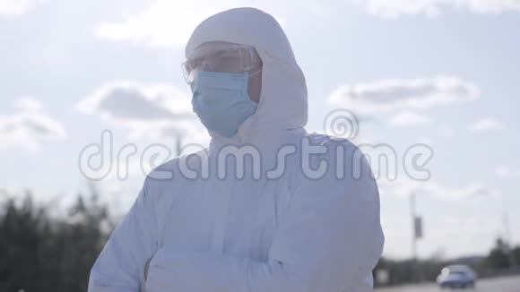 穿着安全套装站在户外的病毒学家的特写肖像穿白色防护服的自信青年视频的预览图