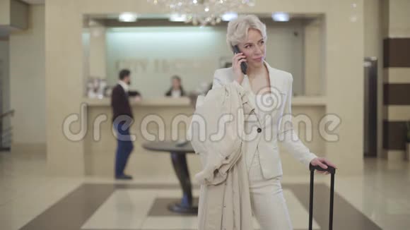 年轻时尚的女商人穿着优雅的西装在豪华的大厅里打电话快乐自信女人的肖像视频的预览图