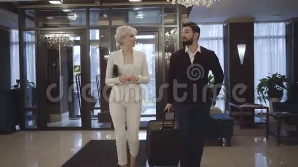 富有的年轻白种人夫妇来到豪华高级酒店的接待处有钱的顾客在前厅散步视频的预览图