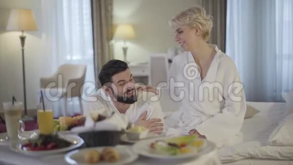 快乐的白种人新娘和新郎在豪华酒店享受蜜月微笑的美女和帅哥聊天视频的预览图