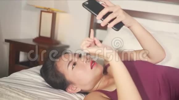 美丽快乐的亚裔韩国女性使用手机社交媒体与男友发短信或享受网上约会视频的预览图
