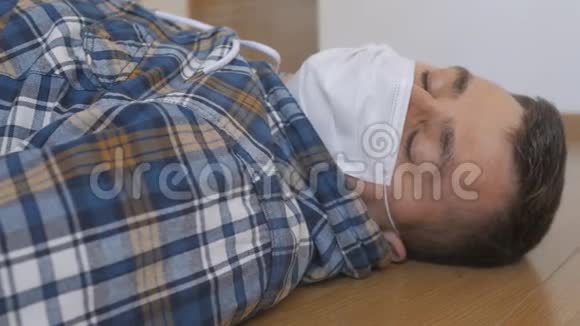 一个戴着医疗面具的男人躺在地上昏迷不醒视频的预览图