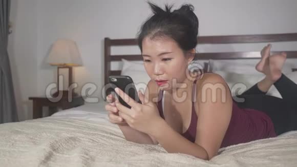 美丽而快乐的亚洲韩国女性使用手机社交媒体与男友发短信或享受在线约会视频的预览图