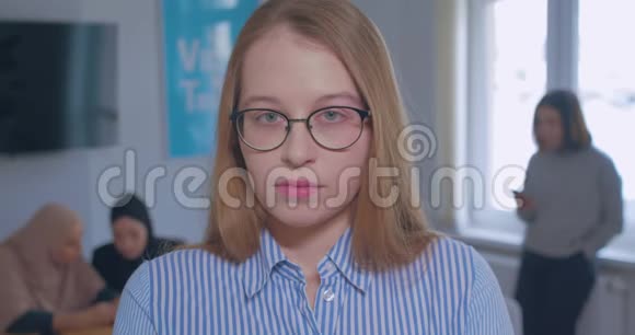 一幅年轻美丽愤怒的白种人金发办公室眼镜背景的肖像视频的预览图