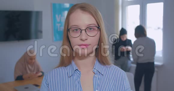 年轻漂亮的白种人金发眼镜办公室背景肖像视频的预览图