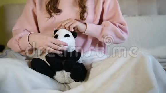一个女孩在熊猫玩具上戴着医用面罩以防止冠状病毒柯维德19的贫血保护概念视频的预览图