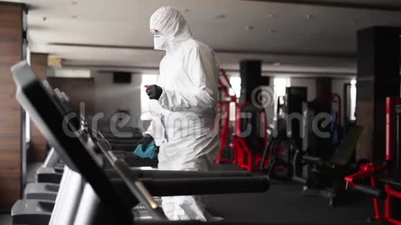 危险物质工人用抗菌消毒喷雾器消毒冠状病毒covid19危害中的健身器材视频的预览图