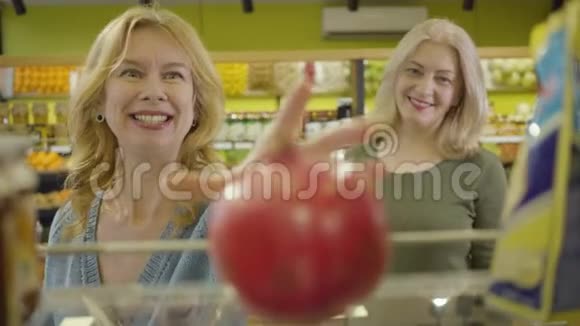 重点变化从多汁的新鲜有机石榴放在货架上的杂货店到两个高加索人的面孔视频的预览图