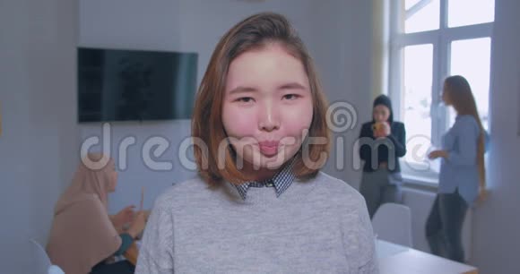 背景中一位年轻美丽严肃愤怒的亚洲办公室女孩的肖像视频的预览图
