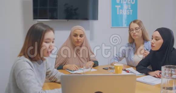 四个自信的不同同事办公室女头巾讨论视频的预览图