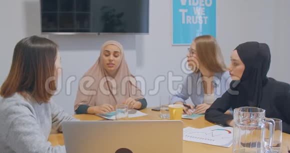 四个自信开朗多元化的同事办公室女人头巾讨论商业计划笑笑笑笑话视频的预览图